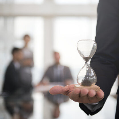 Businessman holding an hour glass, signifies the importance of being on time